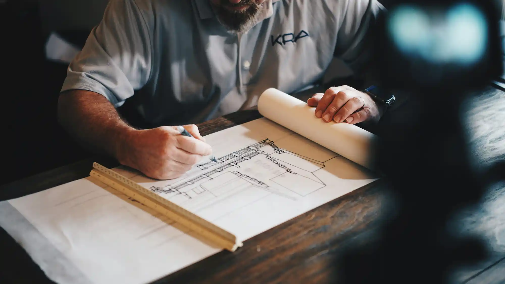Contractor reviewing a home renovation floor plan at a work table